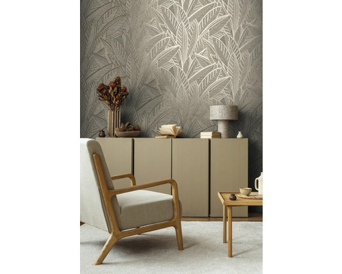 Obývací pokoj s tapetou s motivem listů, křeslem, komodou a příručním stolkem