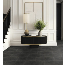 Vstupní prostor s tmavou podlahou, stolem, lampou a schodištěm