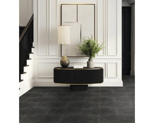 Vstupní prostor s tmavou podlahou, stolem, lampou a schodištěm