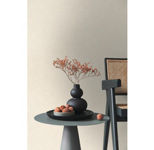 Dekorativní interiér s malým stolem, vázou, sušenými květinami a ovocem vedle židle.