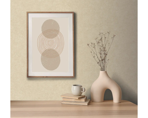 Dekorativní scéna s abstraktním uměleckým dílem v rámu, vázou s květinami, knihami a šálkem na stole.