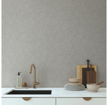 Kuchyňská scéna s umyvadlem, baterií, nádobím a prkénky na krájení před světle šedou stěnou