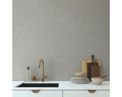 Kuchyňská scéna s umyvadlem, baterií, nádobím a prkénky na krájení před světle šedou stěnou