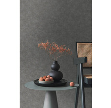 Detail stolu s dekorací před tmavou tapetou.