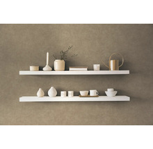 Dvě bílé police s dekorativními předměty na zdi