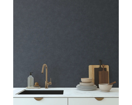 Kuchyňský dřez s baterií, nádobí, prkénka a mycí prostředek na kuchyňské desce před zdí