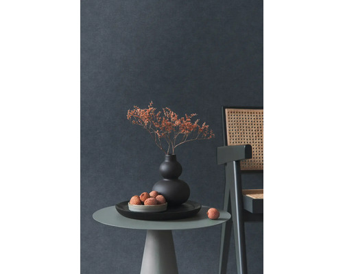 Dekorativní zátiší se sušenými květinami ve váze, miskou s ovocem a židlí na odkládacím stolku před tmavou stěnou