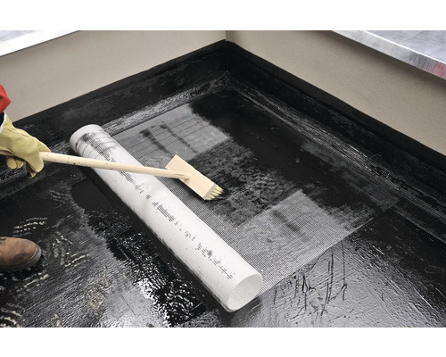 Zpracování těsnicí hmoty s výztužnou tkaninou a štětcem.