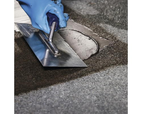 Obkladač s hladítkem při spárování dlaždic