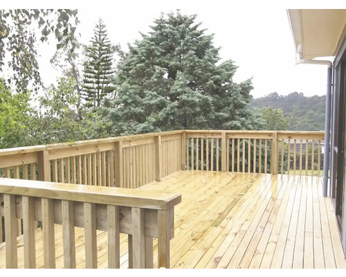 Dřevěná terasa se zábradlím a výhledem do zeleně