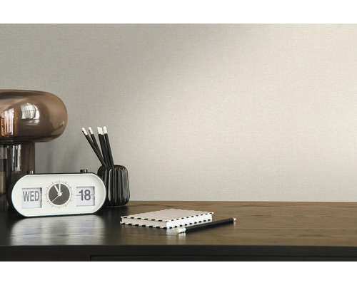 Detailní pohled na béžovou tapetu se stolem a příslušenstvím