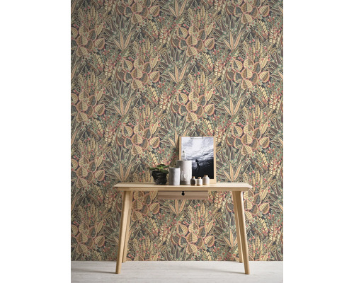 Pohled na pokoj s tapetou s květinovým vzorem a světlým dřevěným stolem.