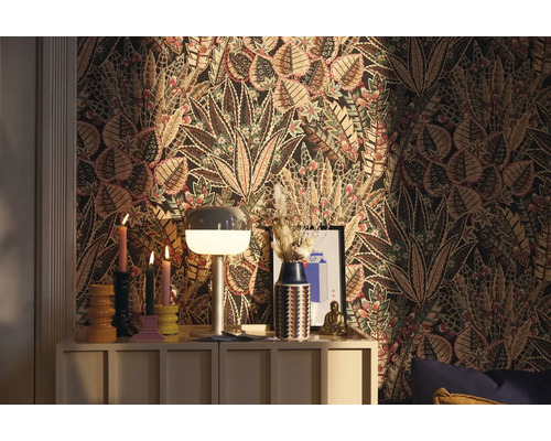 Ozdobný pokoj s květinovou tapetou, komodou a dekorativními předměty.