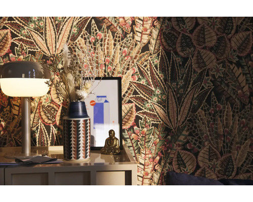 Dekorativní pokoj s vzorovanou tapetou, lampou, vázou se sušenými květinami a figurkou Buddhy