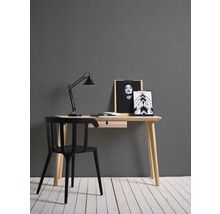 Psací stůl se židlí, stolní lampou a dekorativními obrázky v pracovně.