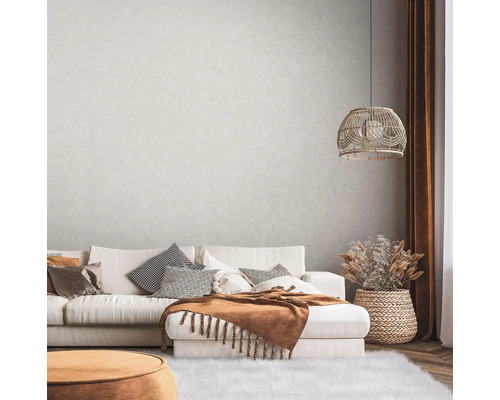 Obývací pokoj s pohovkou, polštáři, dekou, lampou a dekorací v útulném designu.