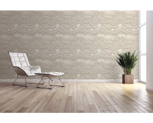 Světlá místnost s vzorovanou tapetou, křeslem a pokojovou rostlinou