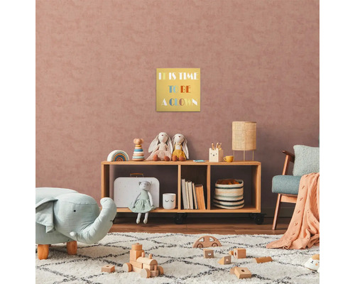 Dětský pokoj s dřevěnou policí, hračkami a zarámovaným obrázkem s nápisem ''It is time to be a clown''.