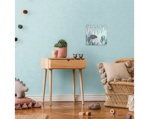 Dekorativní scéna dětského pokoje s dřevěným odkládacím stolkem, plátěným potiskem, hrnkovými rostlinami a ratanovým křeslem