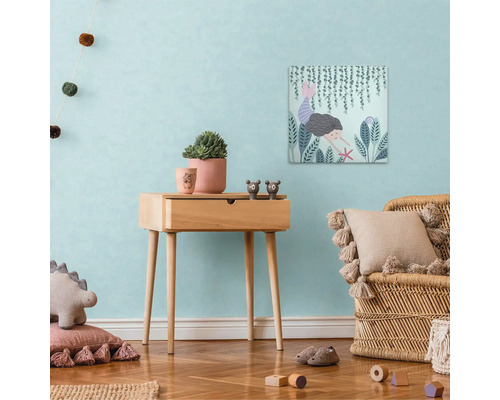 Dětský pokoj s dřevěným stolem, dekoracemi a nástěnnou malbou s motivem mořské panny.