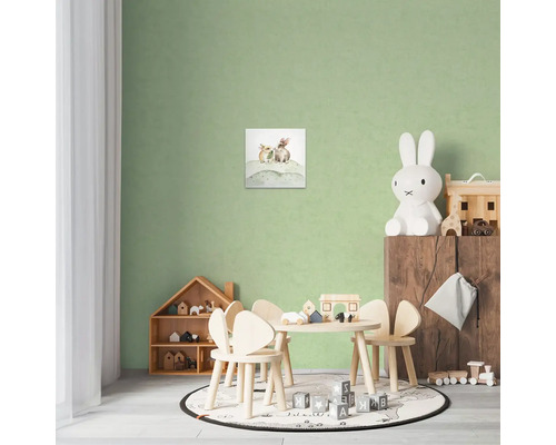 Dětský pokoj s obrázkem zajíčků, dřevěným stolem a židlemi, policí na hračky a dekoracemi