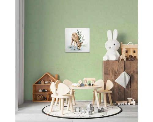 Dekorativní dětský pokoj s obrázkem jelena na zdi, stolem se židlemi a hračkami.