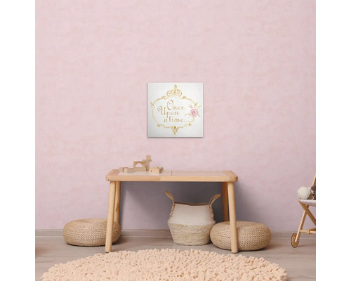 "Scéna dětského pokoje se stolem, kobercem, pufy a nástěnnou malbou s textem ""Bylo nebylo"""