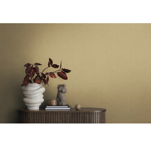 Detailní záběr místnosti se strukturovanou tapetou, příborníkem, vázou na květiny a dekorativními prvky.