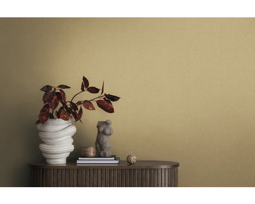 Detailní záběr místnosti se strukturovanou tapetou, příborníkem, vázou na květiny a dekorativními prvky.