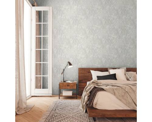 Ložnice s dvoulůžkem, nočním stolkem, lampou a vzorovanou tapetou