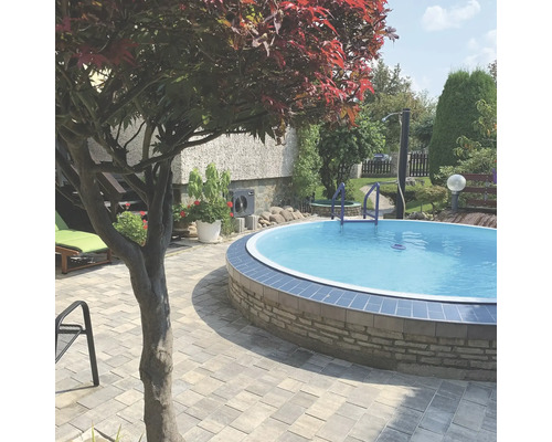 Kulatý bazén na zahradě s kamenným obrubníkem a žebříkem.