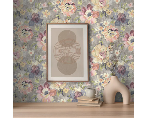 Dekorativní interiér s květinovou tapetou, zarámovaným obrázkem a vázou.