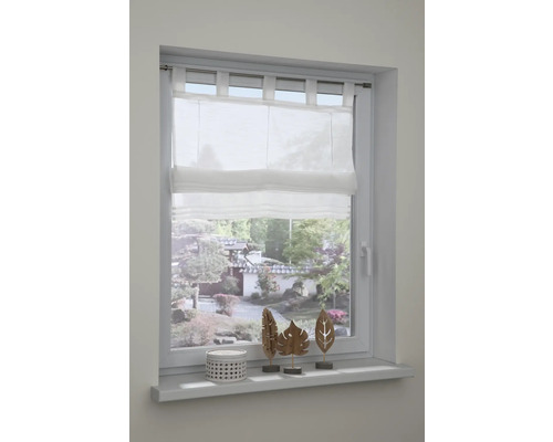Bílá římská roleta v okně s dekorací na parapetu
