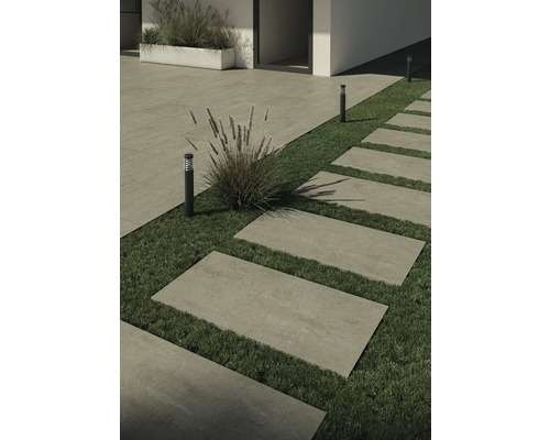 Zahradní chodník s obdélníkovými kamennými deskami v trávě a zahradním osvětlením