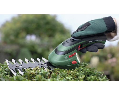 Akumulátorové nůžky stříhají keře s rukavicemi a logem Bosch.