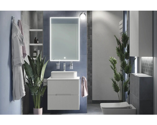 Moderní koupelna s umyvadlem, zrcadlem s osvětlením a toaletou.