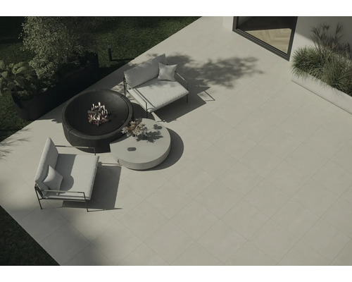 Pohled shora na zahradní scénu s čtvercovými terasovými deskami, ohništěm, dvěma křesly a kulatým stolem