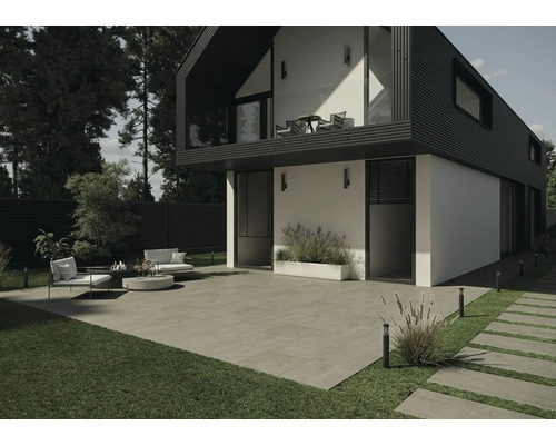 Vnější pohled na moderní dům s terasou, zahradním nábytkem a dlažebními kostkami