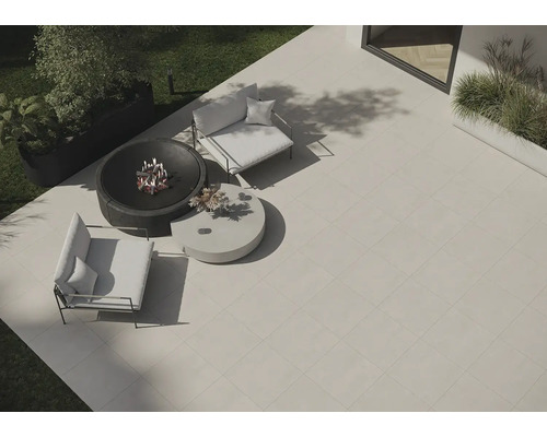 Zahradní scéna s terasovými dlaždicemi, ohništěm a zahradním nábytkem.