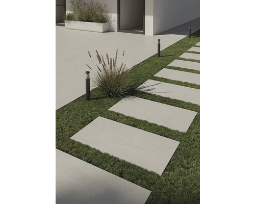 Exteriér s obdélníkovými terasovými dlaždicemi na trávníku a decentním venkovním osvětlením