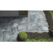 Zahrada se šedými terasovými dlaždicemi, okrasným štěrkem a rostlinami