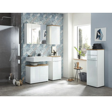 Světlá koupelna s umyvadlem, zrcadlovou skříňkou, závěsnou skříňkou a vysokou skříňkou v bílé barvě s dřevěným povrchem před vzorovanou stěnou