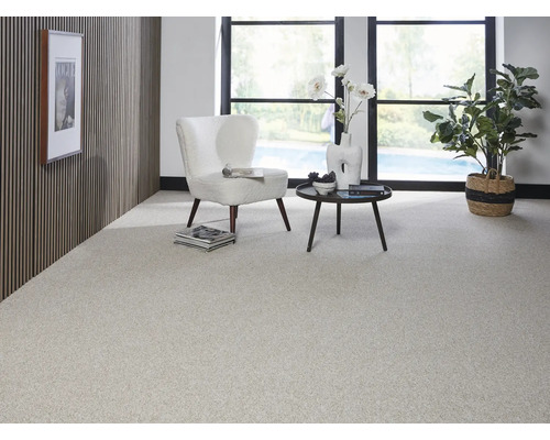 Světlý obývací pokoj s kobercem, křeslem a stolem