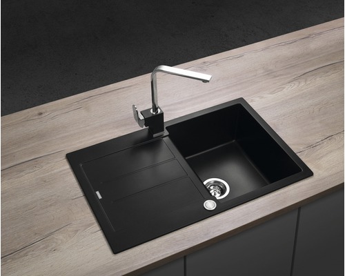 Černý kuchyňský dřez s odkapávací plochou a vodovodní baterií na pracovní desce