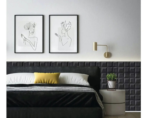 Ložnice s postelí, nočním stolkem, nástěnnou lampou a dvěma zarámovanými uměleckými tisky