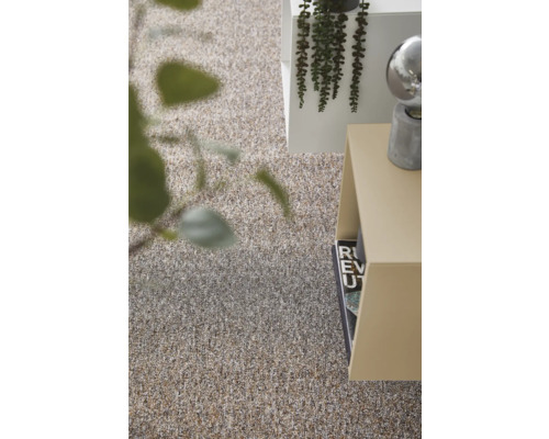 Detailní záběr koberce vedle regálu a dekorace.