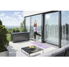 Terasa s úložným boxem, stolem a ženou cvičící jógu