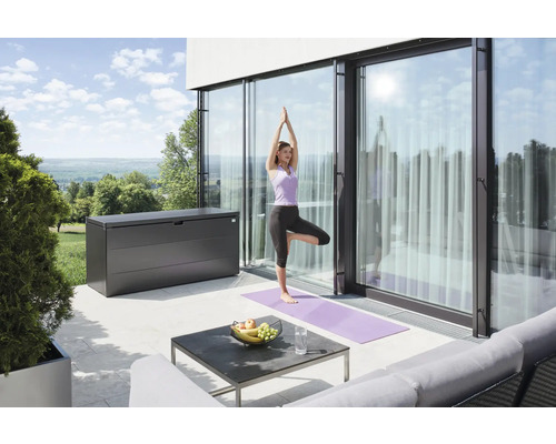 Terasa s úložným boxem, stolem a ženou cvičící jógu