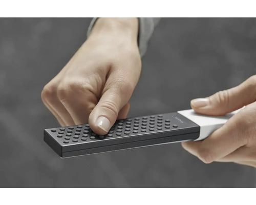 Osoba drží v ruce struhadlo na zeleninu