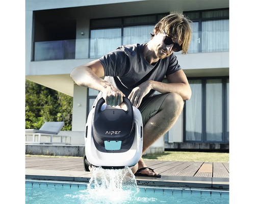 Muž pouští bazénového robota Aiper do bazénu.